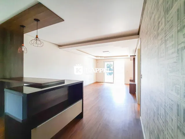 Sala de estar com piso de madeira e móveis escuros.