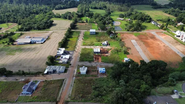 Vista aérea de uma propriedade rural com campos abertos e estruturas dispersas.