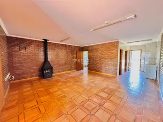 Sala de estar com piso de cerâmica e paredes de tijolo aparente.