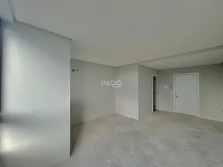 Interior de um cômodo com piso de concreto cru e paredes brancas.