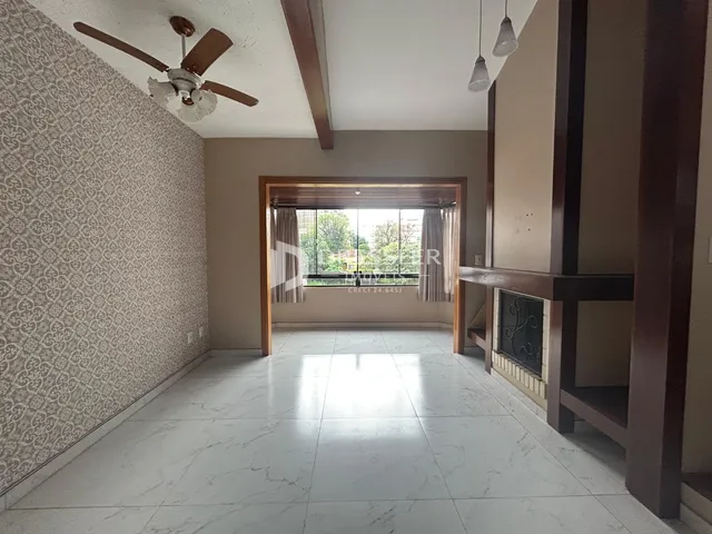 Vista de um corredor interno com piso de cerâmica e parede decorada.