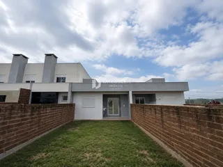 Fachada de uma casa em Lajeado, Brasil, com muro de tijolos e gramado.