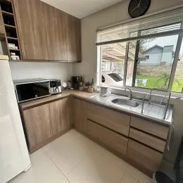 Cozinha com armários de madeira e janela.