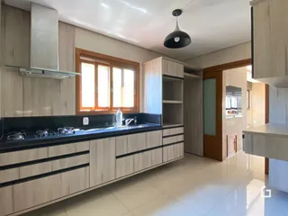 Cozinha com armários e bancadas de madeira clara.