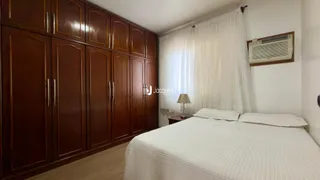 Quarto com armários de madeira e cama de casal em um imóvel.