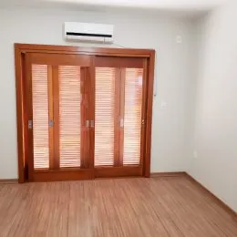 Foto de uma porta de madeira com venezianas em um ambiente interno.