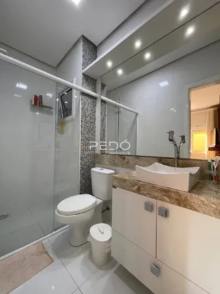 Foto de um banheiro com piso de cerâmica e louças sanitárias brancas.