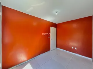 Uma sala com paredes laranjas e piso claro.