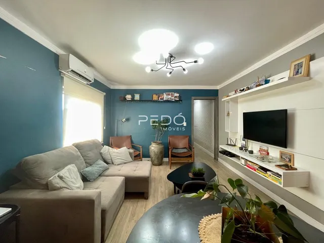 Sala de estar com sofá e painel de TV em um apartamento no Brasil.