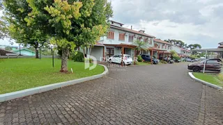 Vista externa de uma residência com jardim e entrada pavimentada.