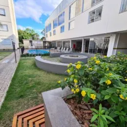 Jardim externo com vegetação e deck de madeira em uma propriedade em Lajeado.