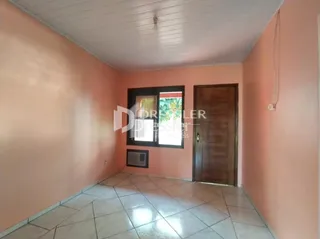 Vista de um corredor interno com paredes cor de rosa e piso de cerâmica.