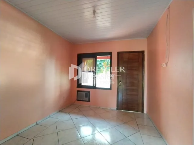 Vista de um corredor interno com paredes cor de rosa e piso de cerâmica.