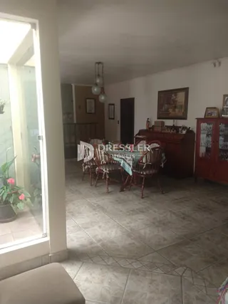 Interior de uma sala com piso de cerâmica e porta de madeira.