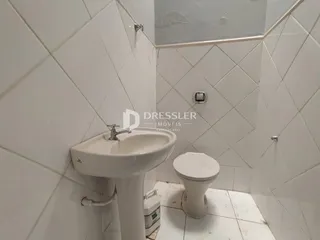 Foto de um banheiro com azulejos brancos e louças sanitárias.