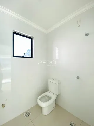 Foto de um banheiro interno com piso claro e azulejos brancos.