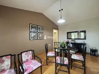 Uma sala de estar com móveis de madeira escura e piso de madeira.