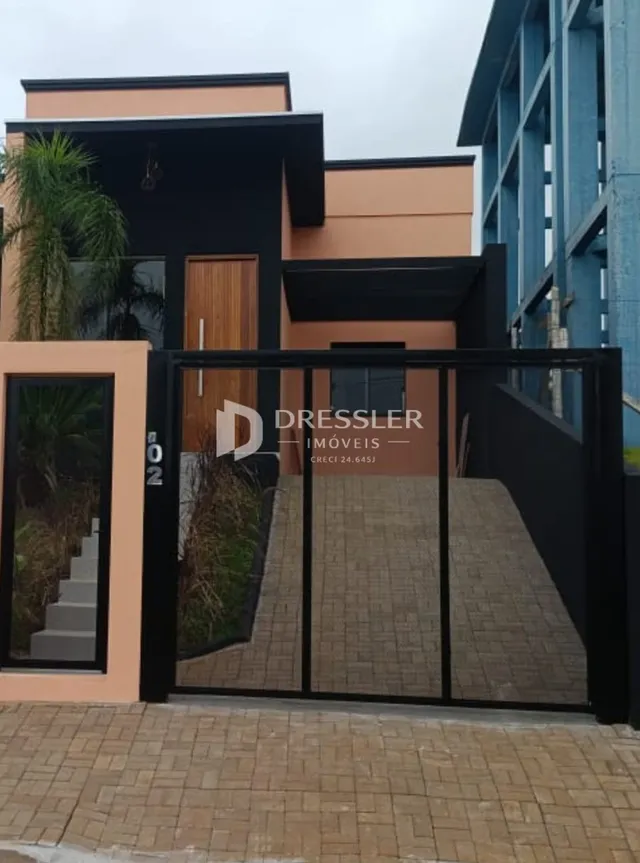 Fachada moderna de uma residência com portão de ferro preta.