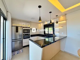 Cozinha moderna com armários brancos e ilha de granito escuro.
