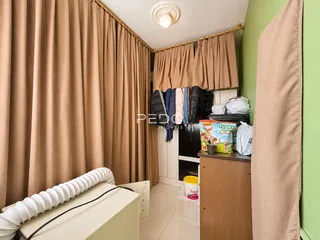 Quarto com cortinas bege e decoração de madeira.