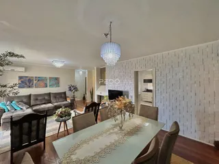 Sala de estar com sofá e mesa de jantar em um imóvel no Brasil.