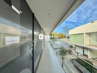 Corredor interno de um imóvel com vista para um pátio externo.
