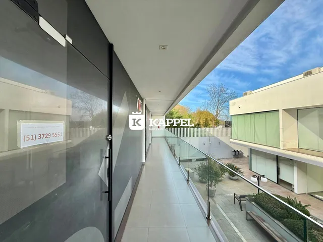 Corredor interno de um imóvel com vista para um pátio externo.