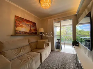 Sala de estar com sofá e vista para o exterior.
