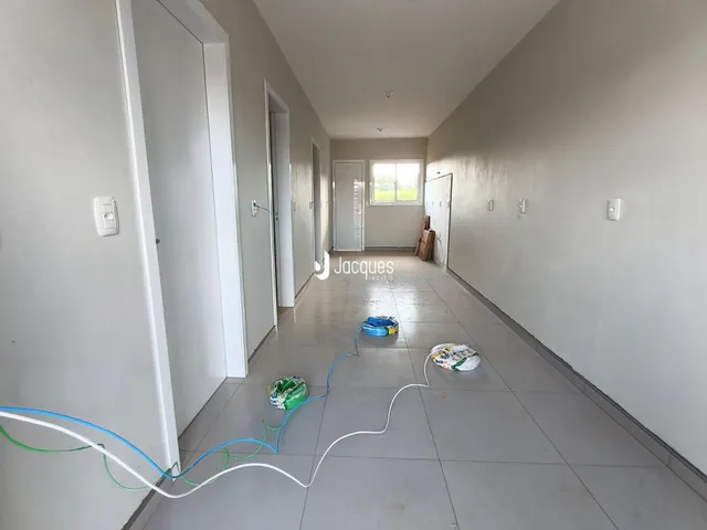 Corredor interno de uma residência com portas brancas.