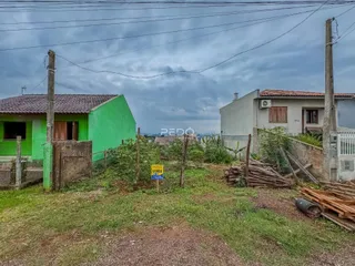 Vista externa de duas casas com cerca e vegetação no quintal.