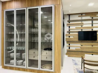 Armários de vidro e madeira em uma sala de estar moderna.