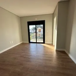 Sala de estar com piso de madeira e porta de vidro.