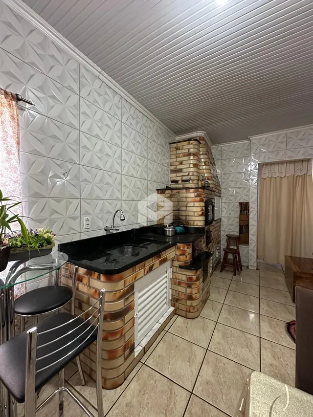 A cozinha apresenta um balcão com revestimento de tijolo aparente.