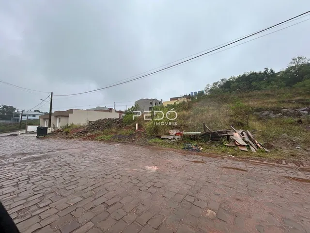 Vista da rua em Lajeado, Brasil, mostrando um terreno com entulho ao lado.