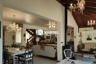 Sala de estar com mesa de jantar e escadaria em ambiente interno.