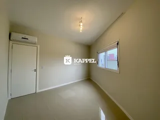 Hall de entrada com piso claro e janela em ambiente interno.