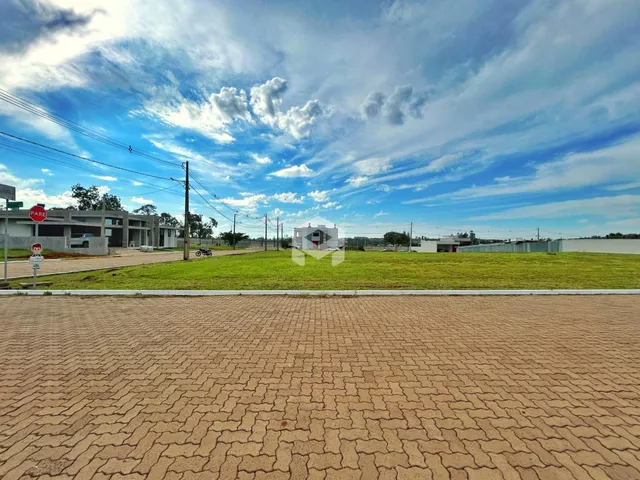 Vista externa de um terreno com piso de tijolos e gramado.