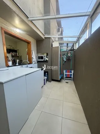 Interior de uma área com piso de cerâmica e grande claraboia em um imóvel em Lajeado.