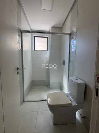 Foto de um banheiro interno com vaso sanitário e box de vidro.