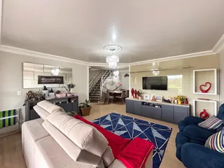 Sala de estar ampla com sofá e decoração moderna.