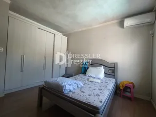 Quarto com cama e armários em um ambiente claro.