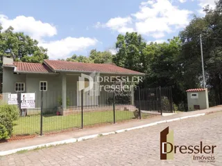 Fachada de uma residência em Lajeado, Brasil, com cerca e jardim.