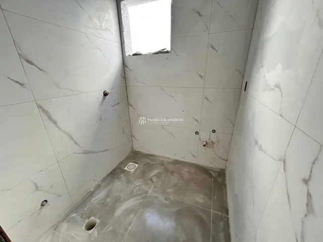 Foto de um corredor interno com paredes brancas e piso claro.