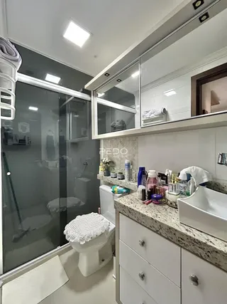 Foto de um banheiro moderno com box de vidro e bancada de mármore.