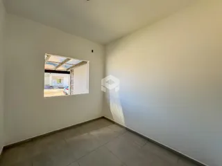 Uma sala com piso de cerâmica e parede branca.