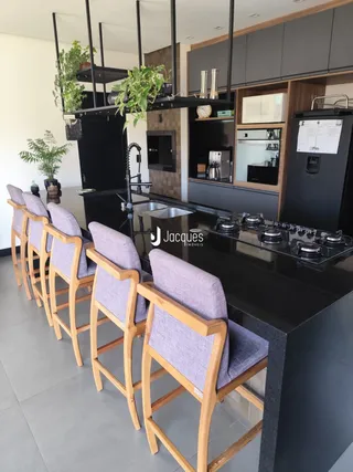 Vista de uma cozinha moderna com ilha e banquetas em Lajeado.