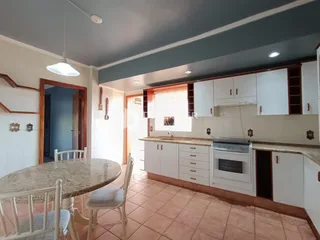 Ambiente interno mostrando uma sala de jantar com cozinha.