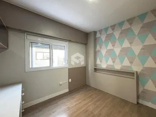 Sala de estar com piso de madeira e parede decorada.