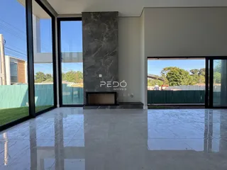 Sala de estar com piso de porcelanato polido e grandes portas de vidro.