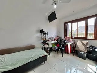 Quarto interno com cama e janela em um imóvel no Brasil.